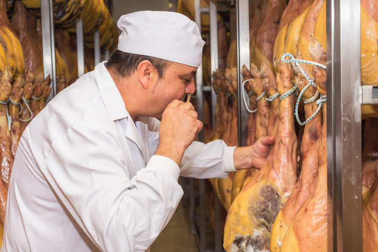 Chef smelling meat in kitchen