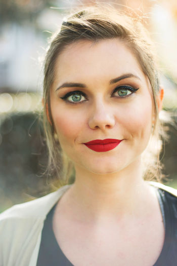 Close-up portrait of beautiful young woman with red lipstick