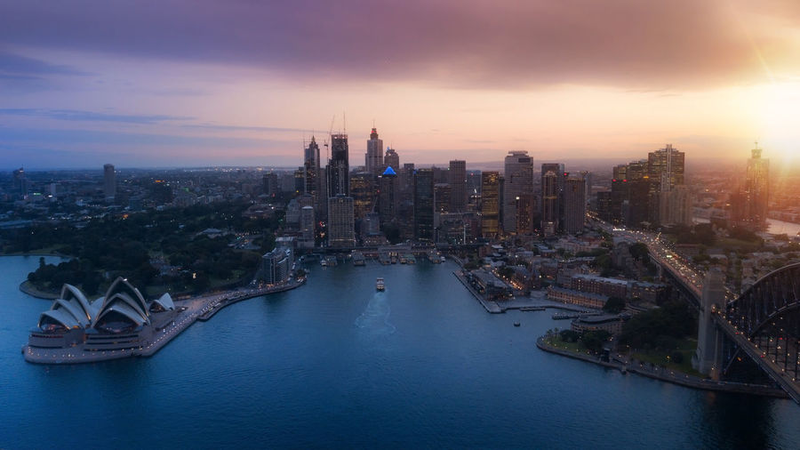 Aerial view of sydney city during amazing golden sunset with opera house and harbour bridge. 
