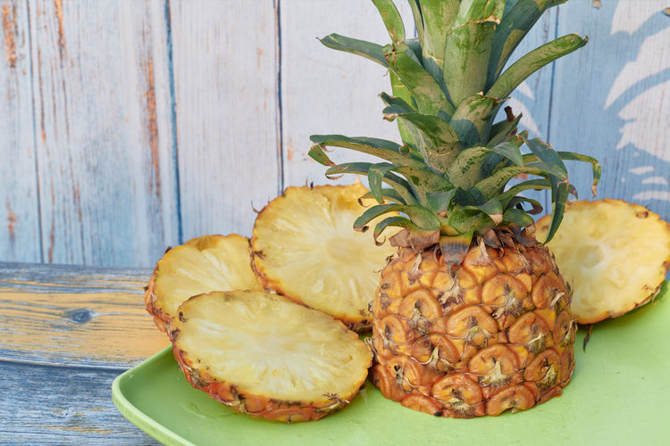 Closeup of juicy ripe pineapple with sliced pieces