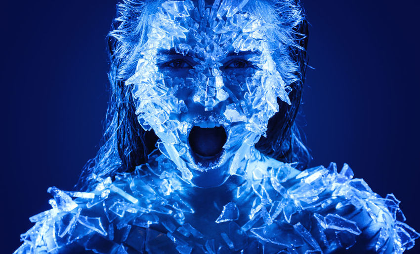 Portrait of woman screaming with shattered glass