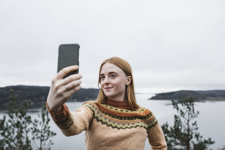 Smiling young woman taking selfie