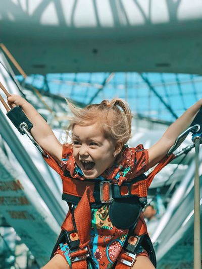 Happy girl with arms outstretched bungee jumping