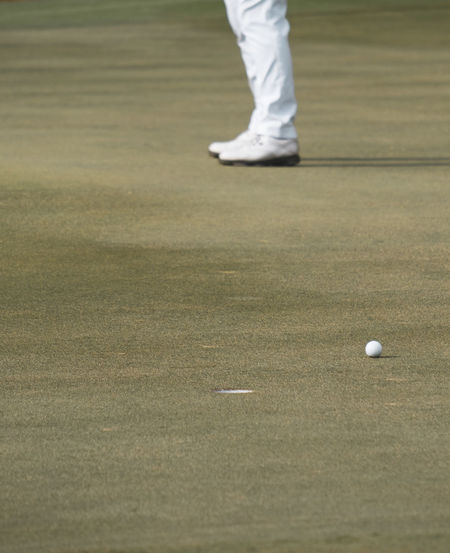 Low section of person standing on golf ball