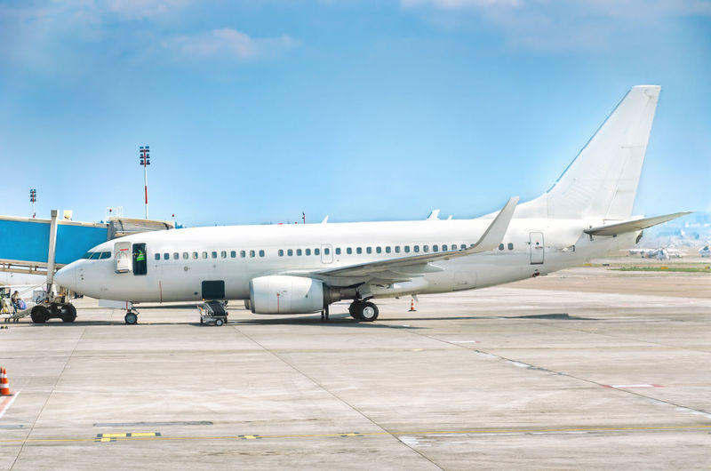 Airplane at the airport at parking lot. preflight check. aircraft maintenance. plane side view. 