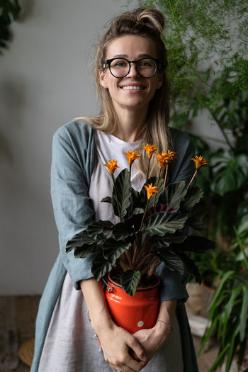 Cheerful woman with potted plants at plant store