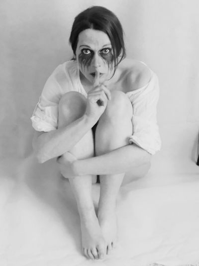 High angle portrait of beautiful woman with spooky make-up sitting on floor