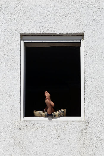 Low section of men with feet up on window