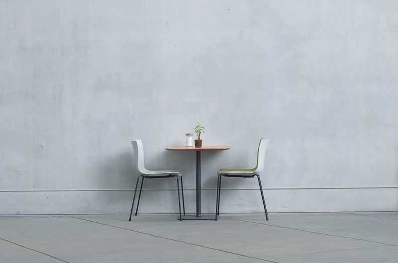 Two chairs and table against the wall