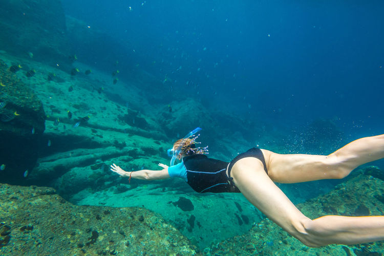 Woman snorkeling over coral reef undersea