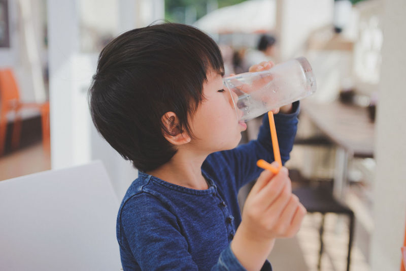 Side view of boy drinking juice at restaurant
