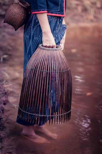 Low section of woman fishing at lake