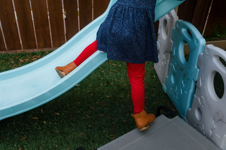 Little girl climbing on slide outside