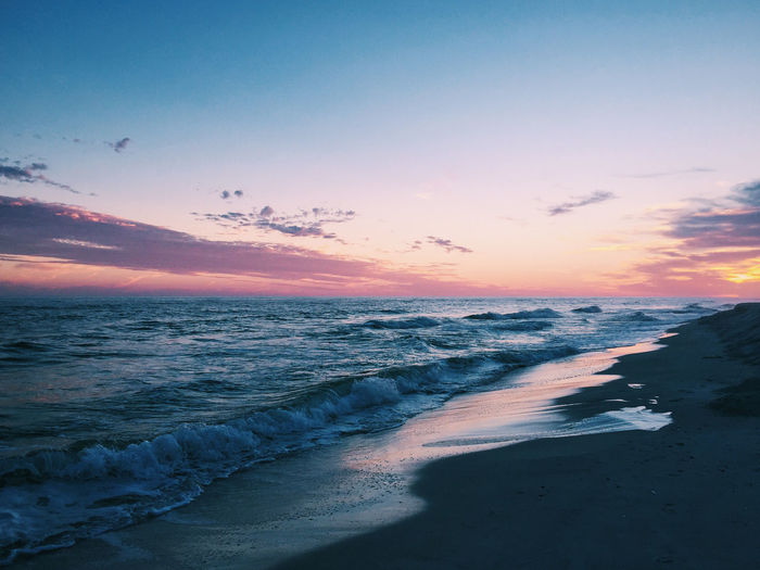 Scenic view of beach against sky during sunset