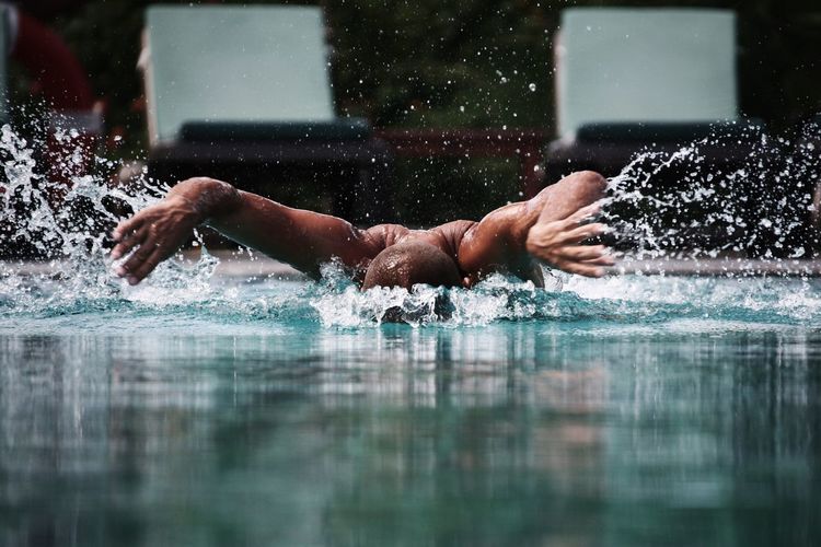 Action shot of man swimming in pool