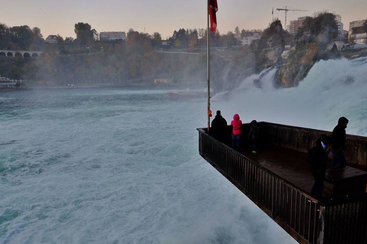 People looking at rhine falls from observation point