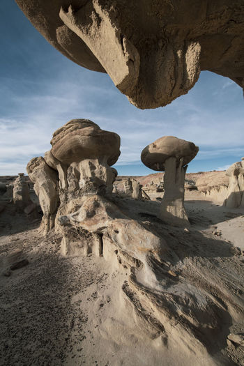 Hoodoos support enormous stones in strange desert formations