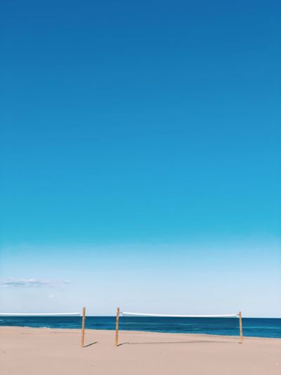 Scenic view of beach against clear blue sky