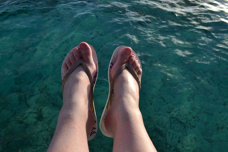 Low section of woman legs over sea