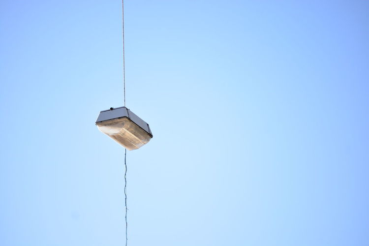 Low angle view of street light hanging against clear sky
