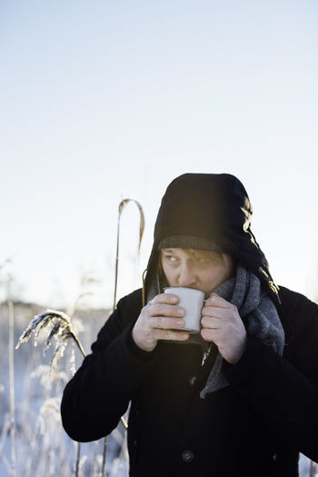 Portrait of man drinking coffee in winter