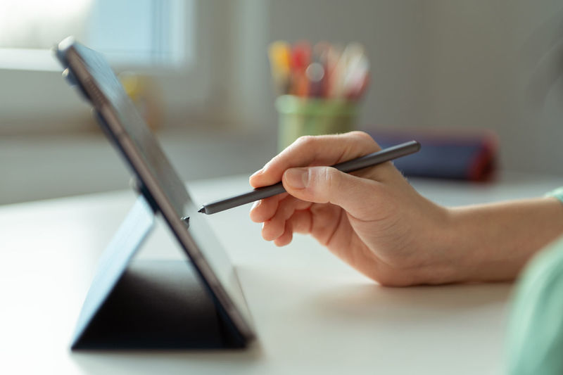Cropped hand of person using digital tablet