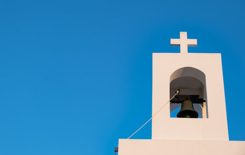 Low angle view of bell against blue sky