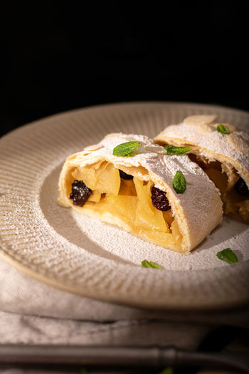 Close up of apple austrian strudel with cinnamon and mint on a plate