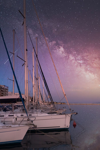 Sailboats on sea against sky at night