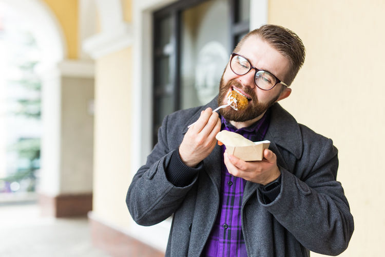 Portrait of young man eating food