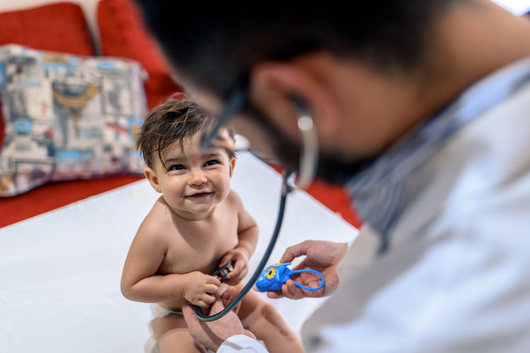 Doctor observing a one-year-old baby
