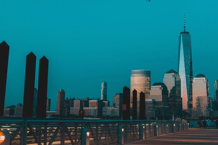 One world trade center against clear blue sky in city at dusk