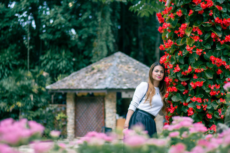 A woman is enjoying the nature of a flower garden.
