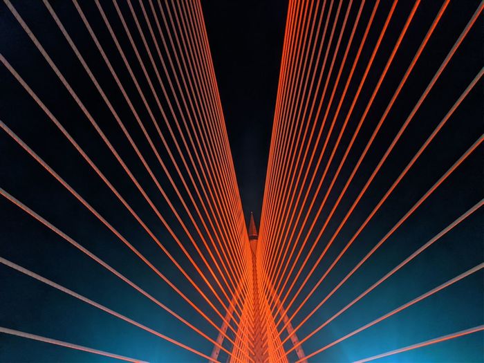 Low angle view of illuminated suspension bridge at night