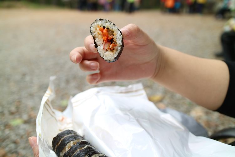 Cropped hands holding sushi