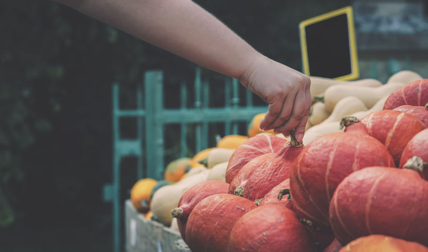 Close-up of hand touching fruit at market stall