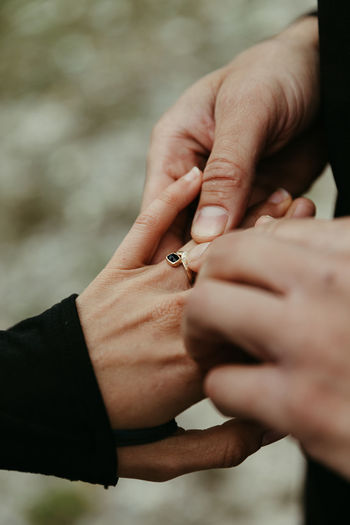 Man puts custom engagement ring on her finger post proposal