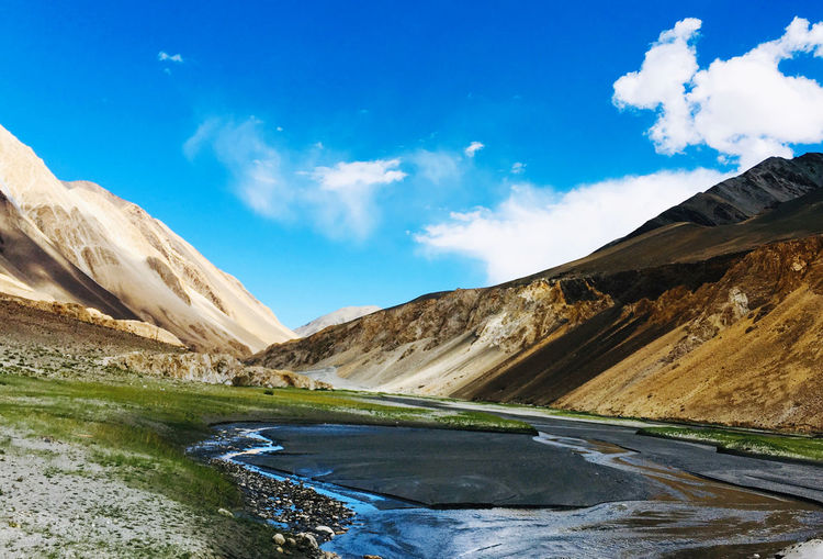 Scenic view of lake by mountains against sky
