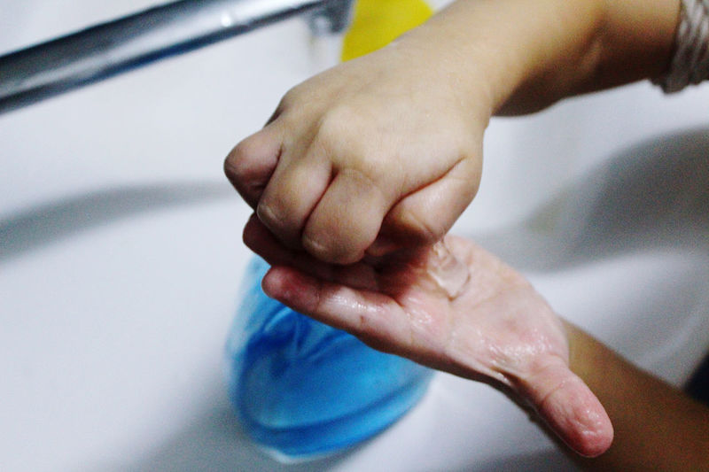 Close-up of boy washing hands in sink