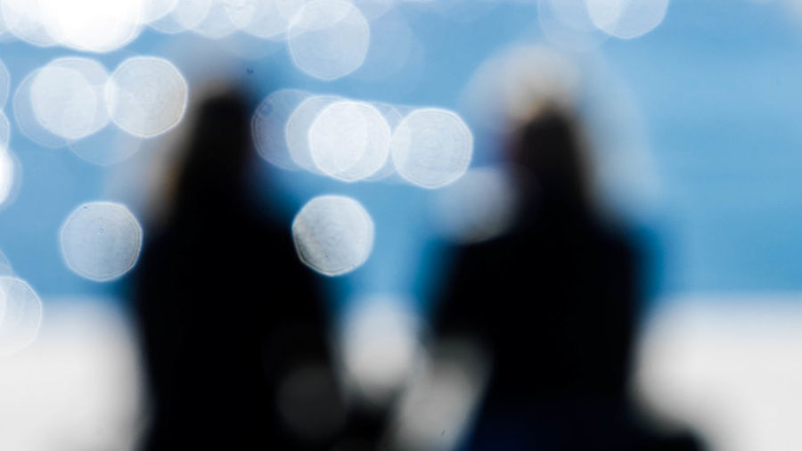 Defocused image of silhouette people against blurred background