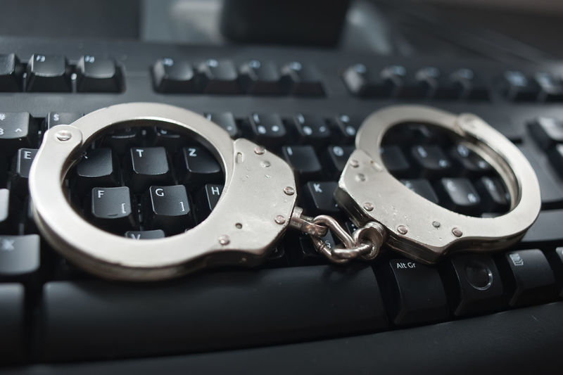 Close-up of handcuffs on computer keyboard
