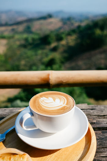 Close-up of coffee on table against landscape