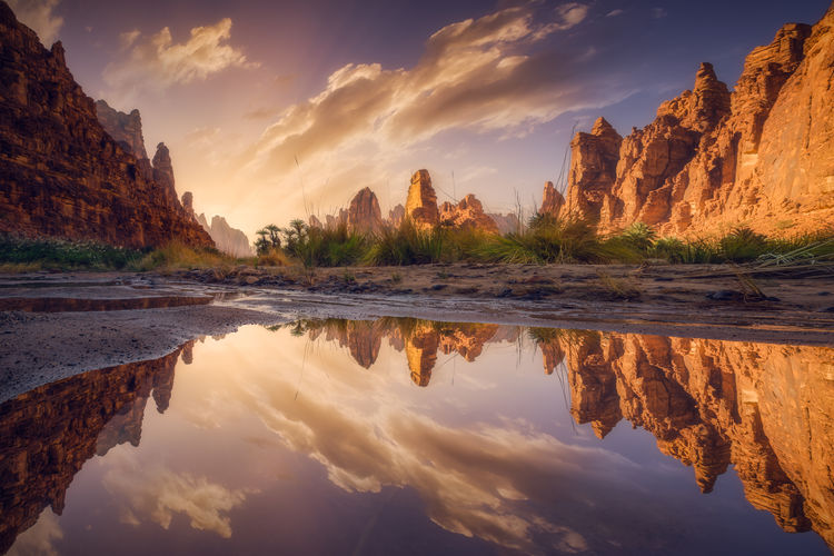 Reflection of rocks in water at sunset