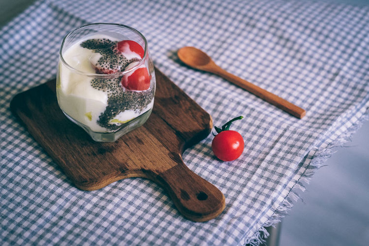 High angle view of cherry tomatoes and yogurt on table