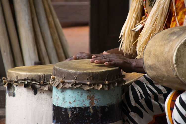 Midsection of man playing bongo drum