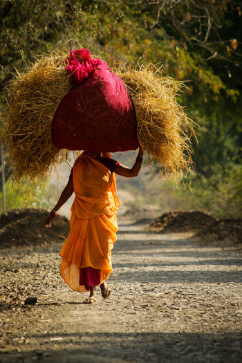 Full length of woman carrying hay
