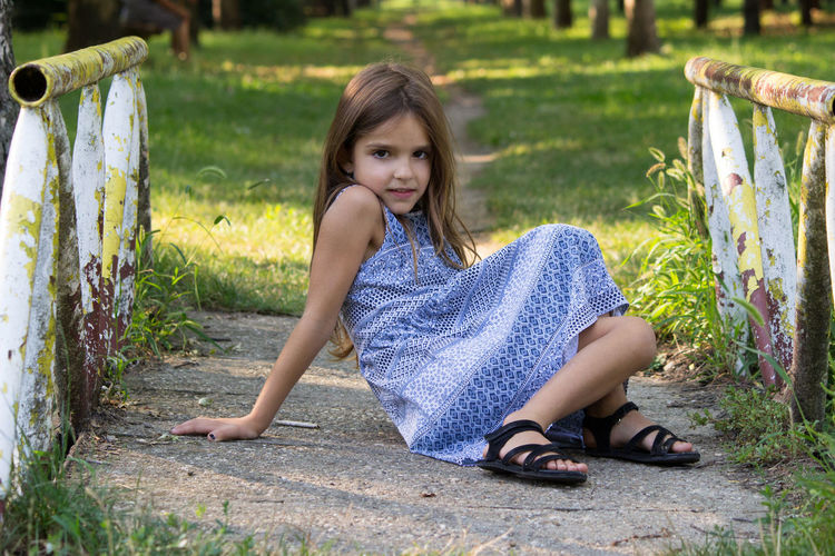 Portrait of girl sitting at park outdoors