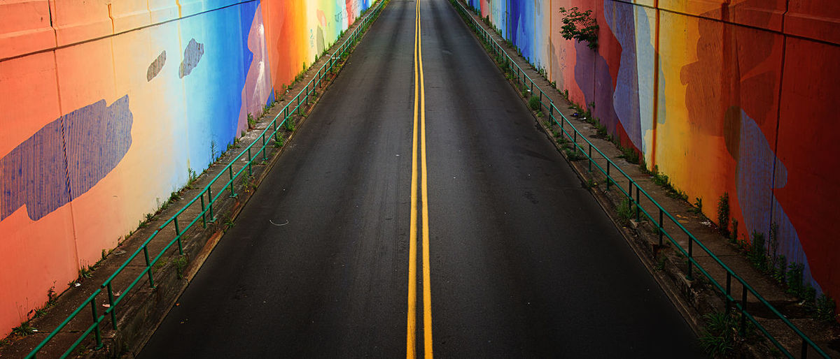 Empty road between colorful walls
