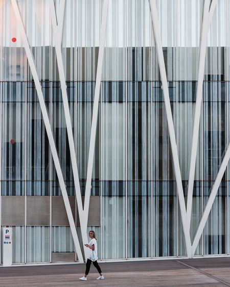 Woman walking by modern office building