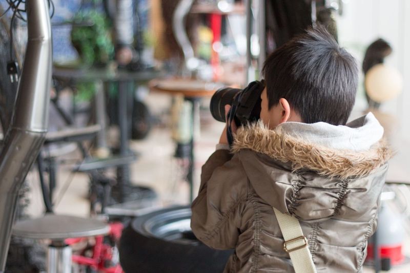 Rear view of boy photographing